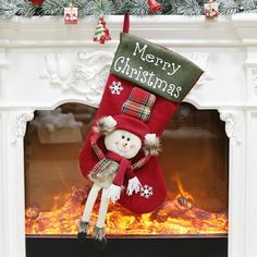 a christmas stocking hanging from a fireplace with a snowman on it's head