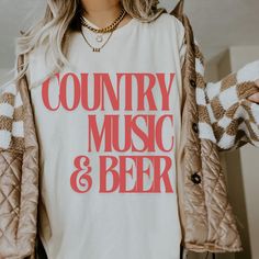 Product Title: Country Music and Beer Comfort Colors Shirt - Festival Ready, Western Music Tee Product Description: Celebrate your love for country music and cold beer with our "Country Music and Beer" Comfort Colors Shirt. Perfect for concerts, festivals, or a casual day out, this soft and durable tee is a must-have for any country music fan. Crafted from premium 100% cotton, it offers a relaxed fit and vintage-inspired feel that gets softer with every wash. Features: Design: Bold "Country Musi Country Tshirt Designs, Country Music Festival, Festival Shirt, Western Music, Music Tees, Western Look, Festival Shirts, Cold Beer, Comfort Colors Shirt