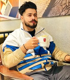 a man sitting in a chair holding a cup