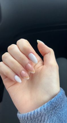 a woman's hand with white and gold manies on it, in the car