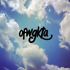 the word otykta written in black ink on a blue sky with white clouds