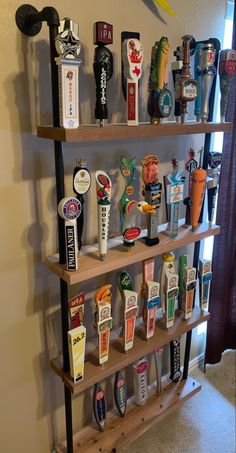 a shelf filled with lots of different types of beer bottle openers on top of wooden shelves