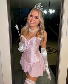 a woman in a pink corset and white gloves is posing for the camera