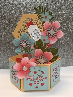 an open box with flowers inside and a tag on the top that says happy birthday