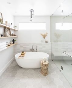 a white bath tub sitting inside of a bathroom next to a walk - in shower