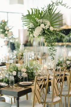 a table set up with flowers and greenery