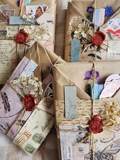 several envelopes covered in paper with flowers and other things on them, all tied together