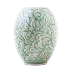 a green and white vase sitting on top of a table