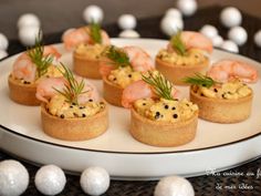 small appetizers are arranged on a white plate with eggs and sprinkles