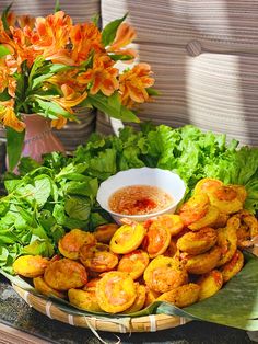 a basket filled with lots of food on top of a table next to orange flowers