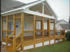 a porch with wooden railings next to a house