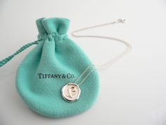 Overview:Seal your love with this awesome Tiffany piece! Offered for sale is a wonderful and very cool Tiffany & Co. Silver Picasso "Sealed with Love" necklace. The piece is crafted from bright and substantial Tiffany silver, yet retains its feminine and delicate feel. It is a wonderful necklace that fits a lifestyle on the go, and can be worn to almost any occasion! The piece is simple, elegant, and classic all rolled into one. Imagine it with your professional office attire ... Now imagine it Tiffany E Co Necklace, Seal Necklace, Tiffany And Co Necklace, Professional Office, Paloma Picasso, Charm Chain, Tiffany And Co, Office Attire, Weekend Wear