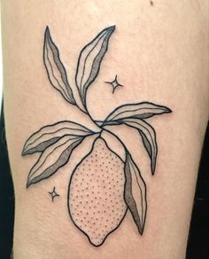 a tattoo with a lemon on it's thigh, and stars around the leg