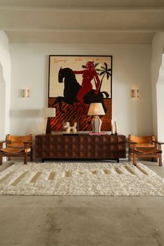 a living room filled with furniture and a painting on the wall