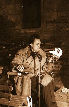 a man sitting in front of a microphone holding a skull