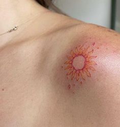 a woman with a sun tattoo on her chest