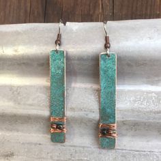 the earrings are made from copper and turquoise stone, with wire wrapped around each ear