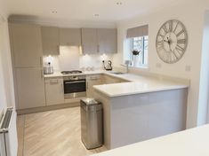 a kitchen with a large clock on the wall above the sink and an island in front of it