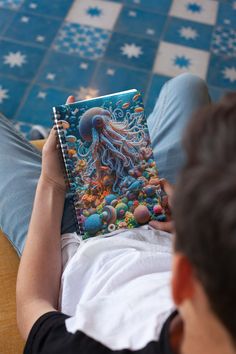 a person sitting on a couch reading a book with an octopus in the ocean cover