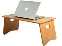 an apple laptop sitting on top of a wooden desk with holes in it's side