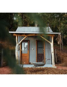 a small metal building sitting in the woods