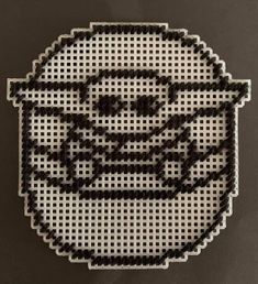 a cross stitch star wars emblem on a black surface