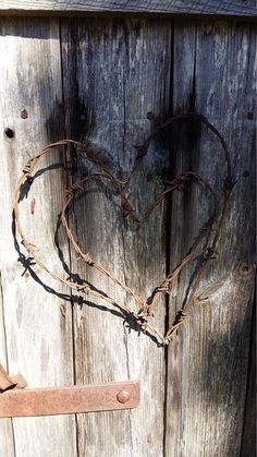 a heart shaped piece of barbed wire attached to a wooden door