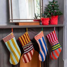 christmas stockings hanging from a mantle in front of a mirror