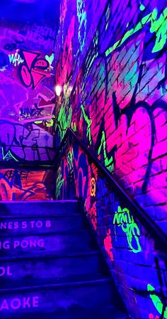 the stairs are covered in graffiti and lit up