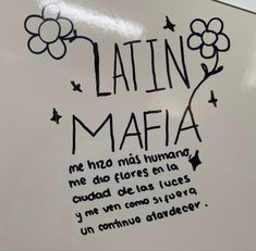 a sign that says latina in spanish and has flowers drawn on it with black ink