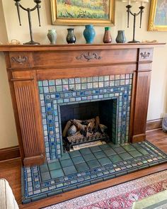 a fireplace in a living room with blue and green tiles on the mantels