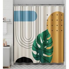 a bathroom with a shower curtain that has an image of a plant on the side