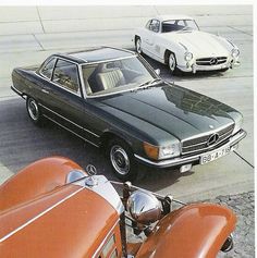 three classic cars parked next to each other in a parking lot, one is orange and the other is white