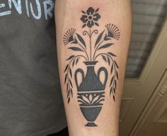 a black and white vase tattoo on the arm