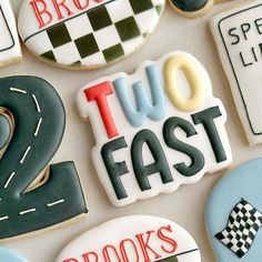 decorated cookies with the words two fast, roads and numbers are displayed on a white surface