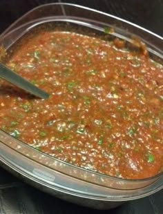 a bowl of chili with a spoon in it