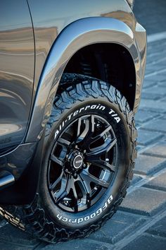 the front end of a truck with black wheels and tire chains on it's tires