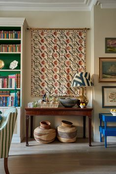 a living room filled with furniture and bookshelves next to a wall covered in books