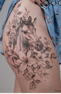 a woman's thigh with a horse and flowers on it