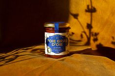 a jar of food sitting on top of a bed next to a shadow cast wall