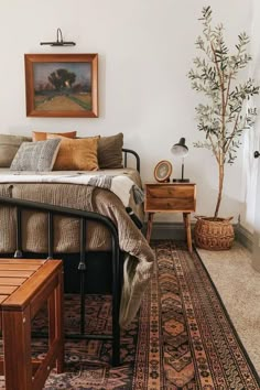 a bed sitting next to a wooden table on top of a rug