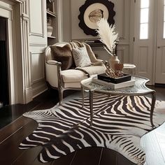 a living room filled with furniture and a zebra rug on top of a hard wood floor