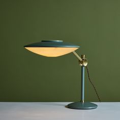 a table lamp with a green shade on the top and a white light on the bottom