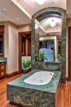 a large bathroom with marble counter tops and wooden floors