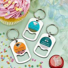 three bottle openers with different designs on them next to a cupcake and sprinkles