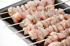 several skewers of meat are on a tray