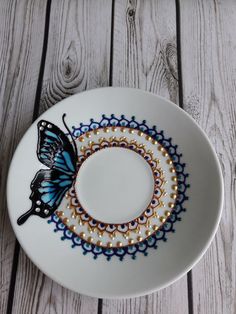 a white plate topped with a blue and black butterfly