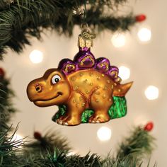 a dinosaur ornament hanging from a christmas tree