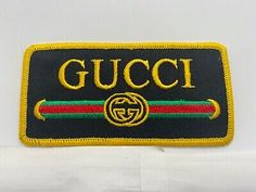 a gucci logo patch on a white background