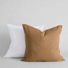 two brown and white pillows sitting next to each other